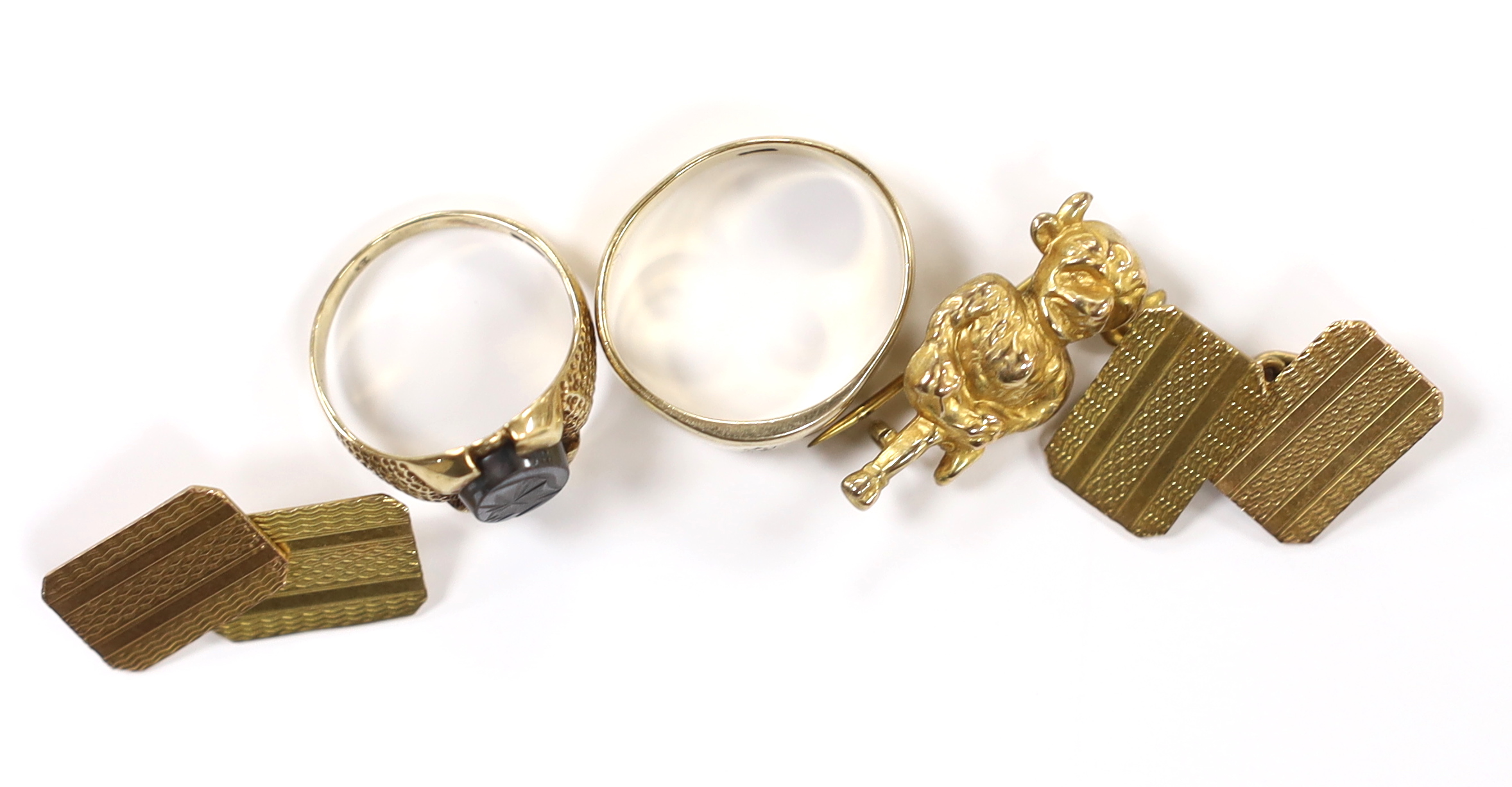 A pair of engine turned 9ct gold cufflinks, a 9ct 'Lincoln Imp' brooch and two 9ct rings including hematite signet ring, gross weight 13.6 grams.